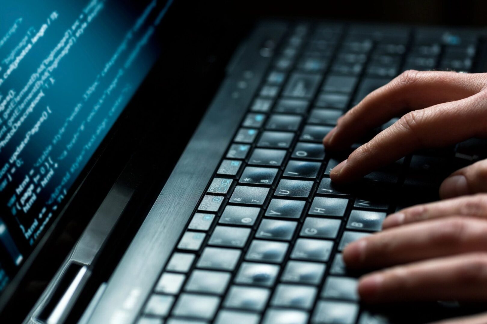 A person typing on a laptop keyboard.