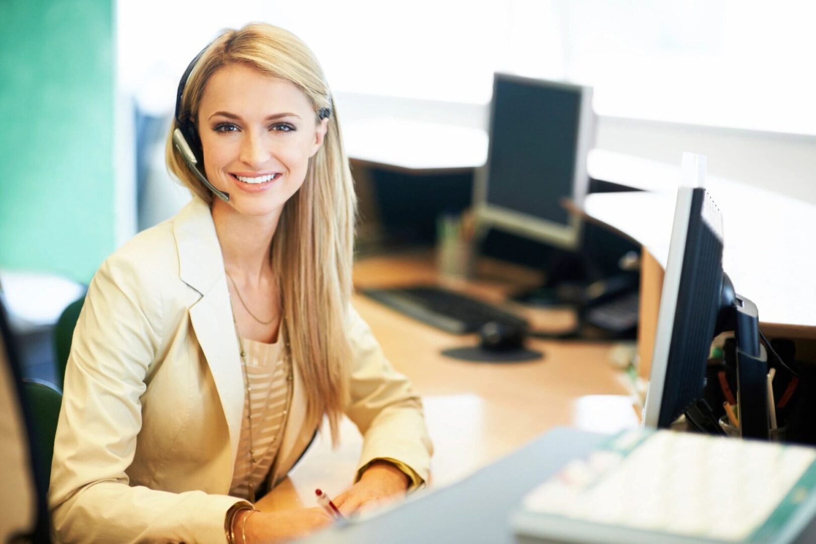 A woman sitting at her desk with headphones on.